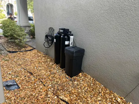 Water softener and brine tank installed at a house corner