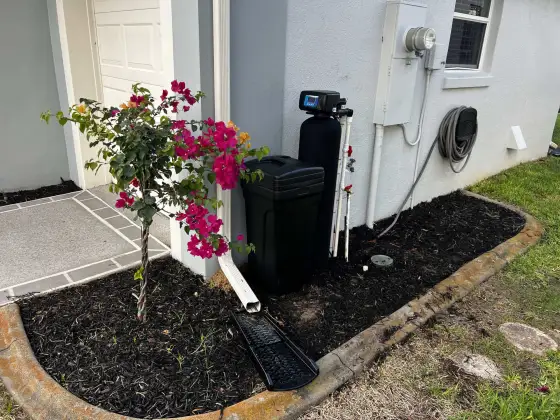 Whole-home water softener installed beside a Florida garage